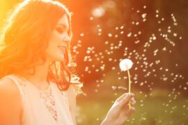 Woman in field with dandelion